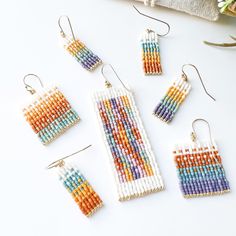 the beaded earrings and earring sets are arranged on top of a white surface