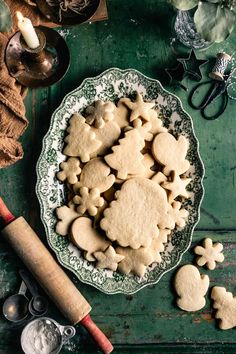 a plate full of cut out cookies on top of a green table with other items