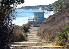 stairs lead down to the beach with a lifeguard tower in the background