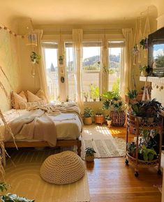 a bed room with a neatly made bed and lots of plants on the windowsill