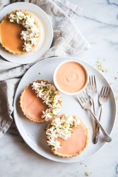 two small desserts on white plates with silverware