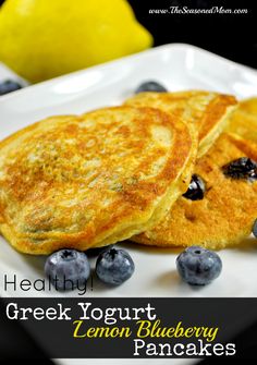 two pancakes on a plate with blueberries and lemons