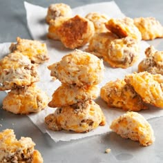 a bunch of cookies that are on top of some parchment paper and sitting on a table