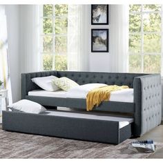 a day bed with pull out trundle and storage underneath it in a living room