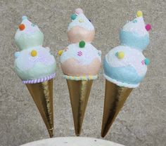 three ice cream cones with sprinkles on them sitting in front of a wall