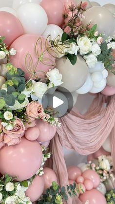 the balloon arch is decorated with pink and white flowers, greenery, and balloons