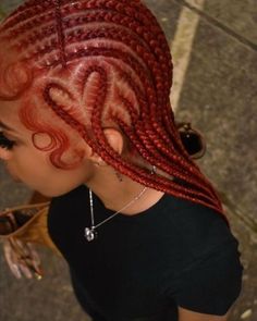 a woman with red braids on top of her head looking down at the ground