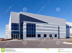 an empty parking lot with a large building in the background