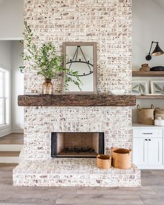 a white brick fireplace with potted plants on the mantle