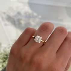 a woman's hand with a gold ring and a diamond engagement ring on it