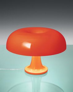 an orange lamp sitting on top of a glass table