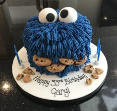 a cookie monster birthday cake with cookies and candles