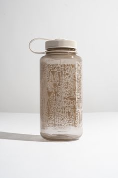 a glass jar with a lid sitting on top of a white table next to a wall