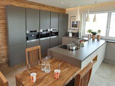 a kitchen with an island table and chairs in front of the stove top ovens