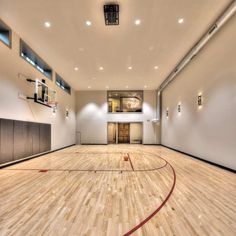 an indoor basketball court with hard wood floors