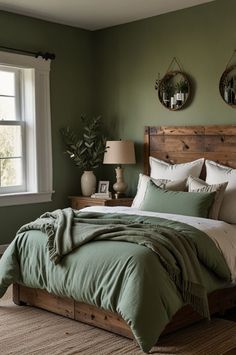 a bed with green sheets and pillows in a bedroom next to a large window on the wall