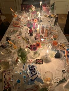 a long table covered with lots of dishes and candles