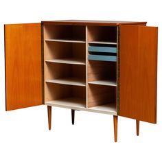 an open cabinet with shelves and drawers on one side, the doors are closed to reveal bookshelves