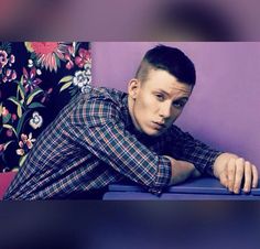 a young man leaning on a blue table