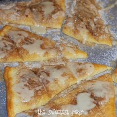 several pieces of pizza sitting on top of a pan covered in icing and powdered sugar