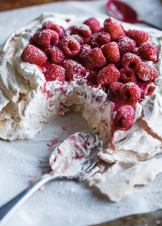 a cake with white frosting and raspberries on top