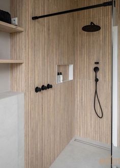 a bathroom with a shower head, shelves and shelving unit in the wall next to it