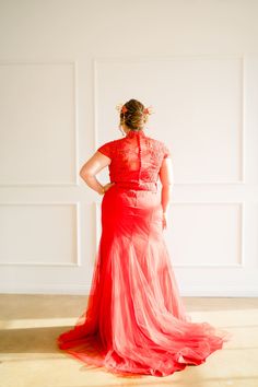 a woman in a red dress is looking away from the camera