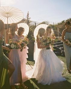 a group of women standing next to each other holding umbrellas