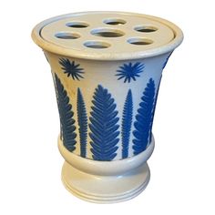 a blue and white planter with holes in it