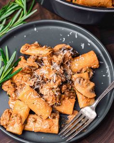 a black plate topped with pasta and meat