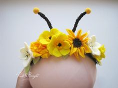 the headpiece is decorated with yellow flowers and black antlers on it's sides