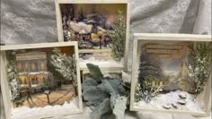 three framed pictures sitting on top of a table covered in snow