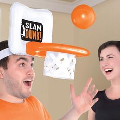 a man and woman playing with an inflatable slam dunk basketball