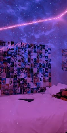 a bedroom with purple lights and pictures on the wall