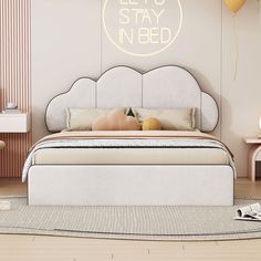 a bedroom with a bed, nightstands and balloons on the wall above it that says let's stay in bed