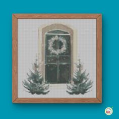 a cross stitch picture with trees and a door in the center, on a blue background