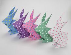 four origami birds are lined up in different colors and patterns, with polka dots on them