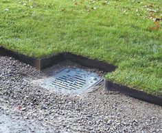 a drain in the ground with grass growing out of it