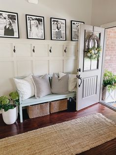 a white bench sitting in front of a door with pictures on the wall above it