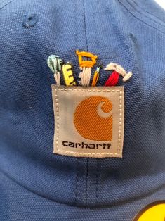 there is a cap with the name carrarti on it and many pins in its pocket