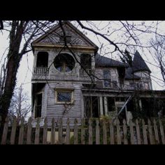 an old house with a wooden fence around it