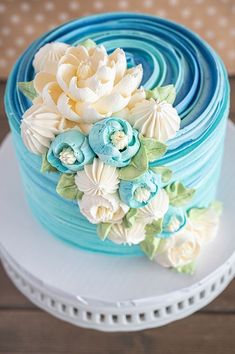 a blue and white cake with flowers on top