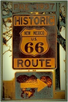 an old route 66 sign in front of a tree