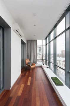 two pictures of a living room with wood flooring and large windows overlooking the city