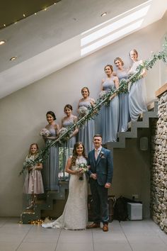 the bride and groom are posing for pictures with their bridal party on the stairs