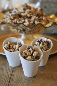 three small cups filled with popcorn sitting on top of a table next to a plate