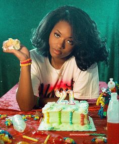 a woman sitting at a table with a birthday cake