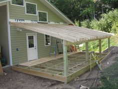 a house being built in the woods with wood framing on the front and side of it