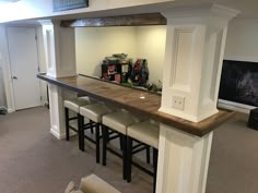 a bar with stools is in the middle of a room