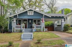 a blue house with an american flag on the front porch and stairs leading up to it